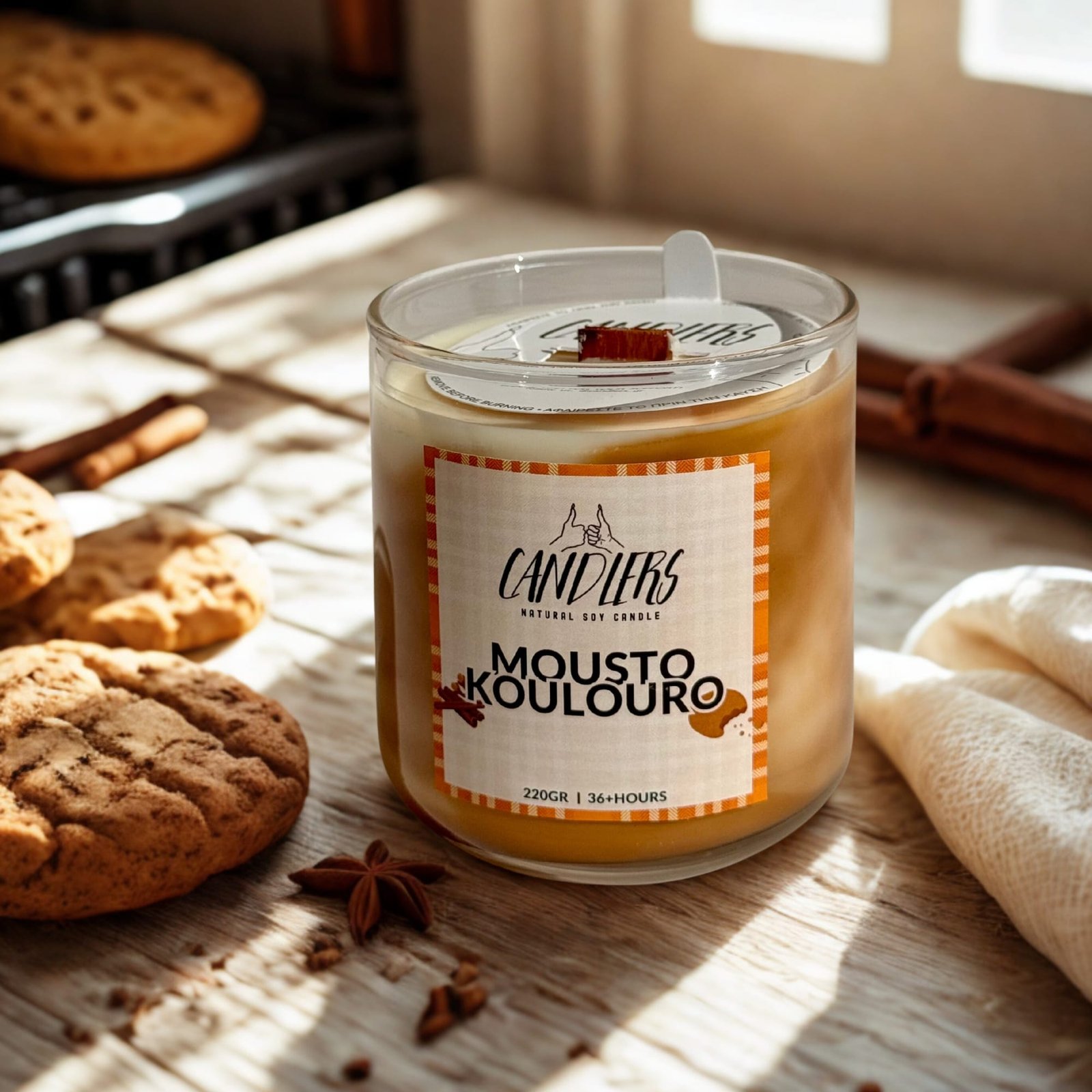 μουστοκουλουρο 220gr Κερί σόγιας με άρωμα μουστοκούλουρο, τοποθετημένο σε ξύλινη επιφάνεια, δίπλα σε φρεσκοψημένα κουλουράκια και ζεστή φθινοπωρινή ατμόσφαιρα.